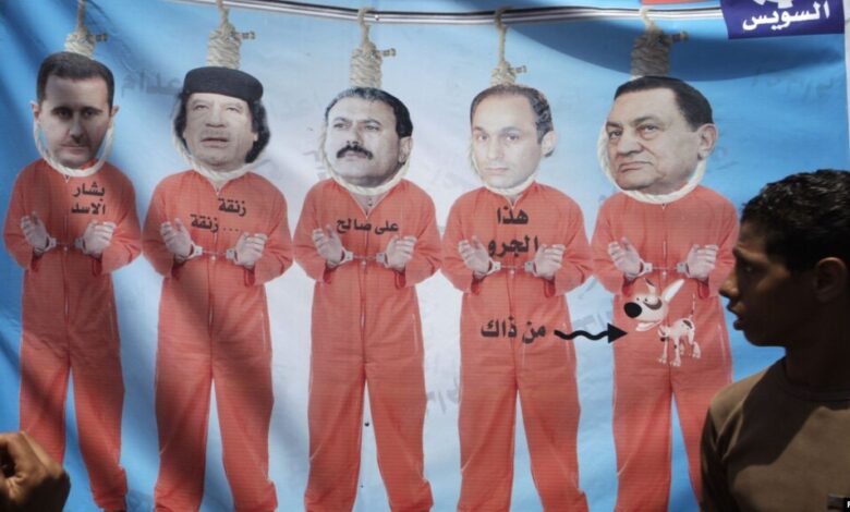 Misir: Oğlan sabiq Misir prezidenti Mubarak, oğlu Gamal, Yəmən prezidenti Ali Abdullah Saleh, Liviya lideri Muammar Gaddafi və Suriya prezidenti Bashar al-Assadin məhbus paltarındakı təsvirinə baxır